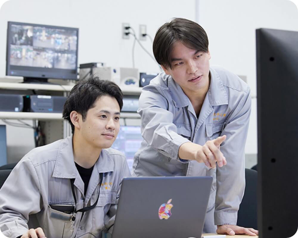 パソコンを見ながら真剣に話し合う社員二人