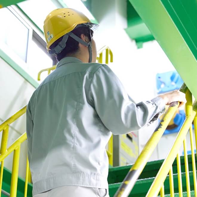階段を登るヘルメットをつけた社員