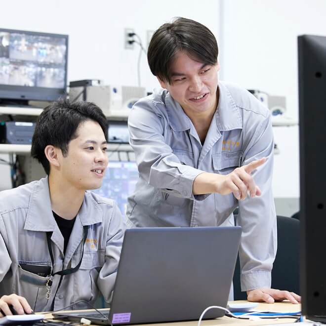 パソコン画面を見ている社員二人